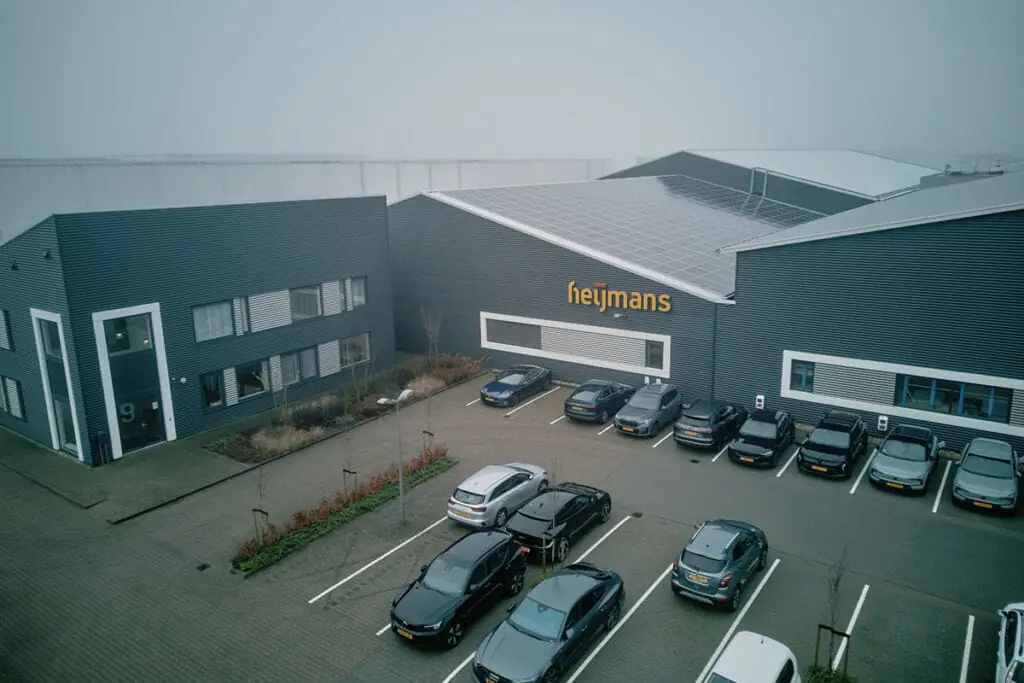Aerofilm-Heijmans-Heereveen_DJI_0353_1200x800-1024x683.jpg.webp Instalación de construcción modular de Heijmans, en los Países Bajos, en la que se muestran modernas soluciones de construcción prefabricada con cubierta solar integrada y diseño sostenible.