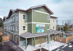 Edificio modular permanente de tres plantas con revestimiento ecológico y un gran mural.