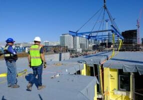 Un equipo de decorado coloca parte de un edificio modular volumétrico